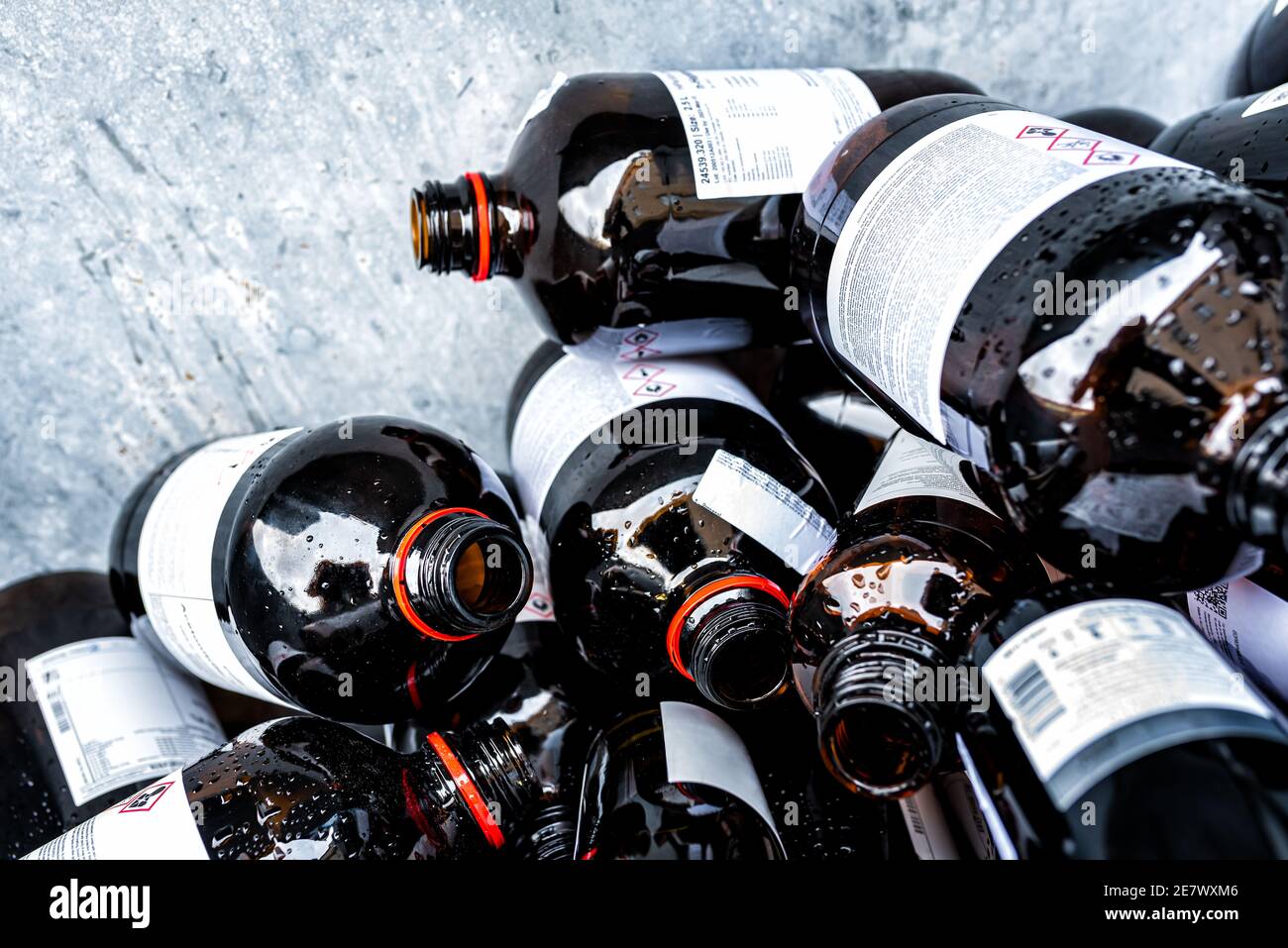 Le molte bottiglie di vetro ambrato contenenti sostanze chimiche e rifiuti dal laboratorio Foto Stock