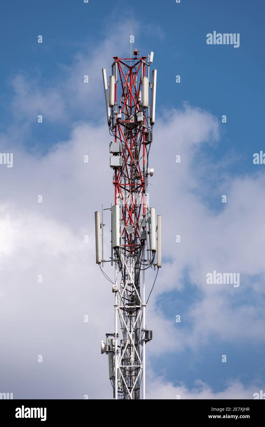 Un palo dell'antenna del telefono cellulare o del telefono cellulare contro un cielo nuvoloso e soleggiato Foto Stock