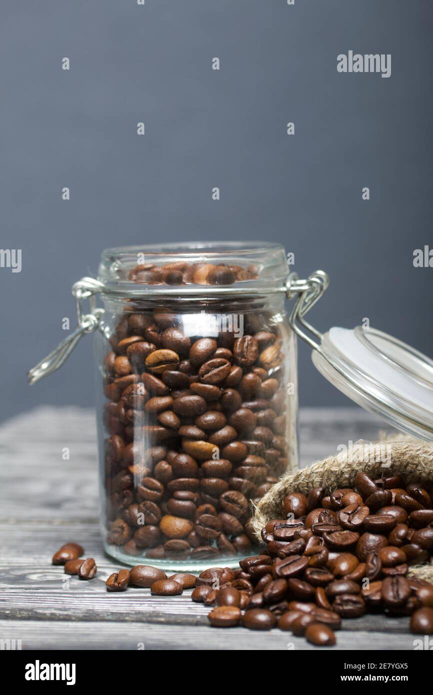 Chicchi di caffè. Versate in un vasetto di borsa di trascinamento e in una borsa di lino. Primo piano. Foto Stock