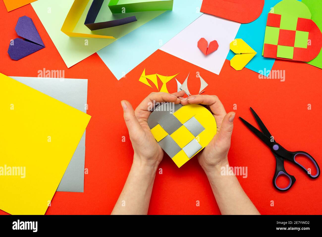 Istruzioni DIY. Guida dettagliata. Il processo di fare un cuore di carta da giallo e grigio carta colorata per San Valentino. Foto Stock