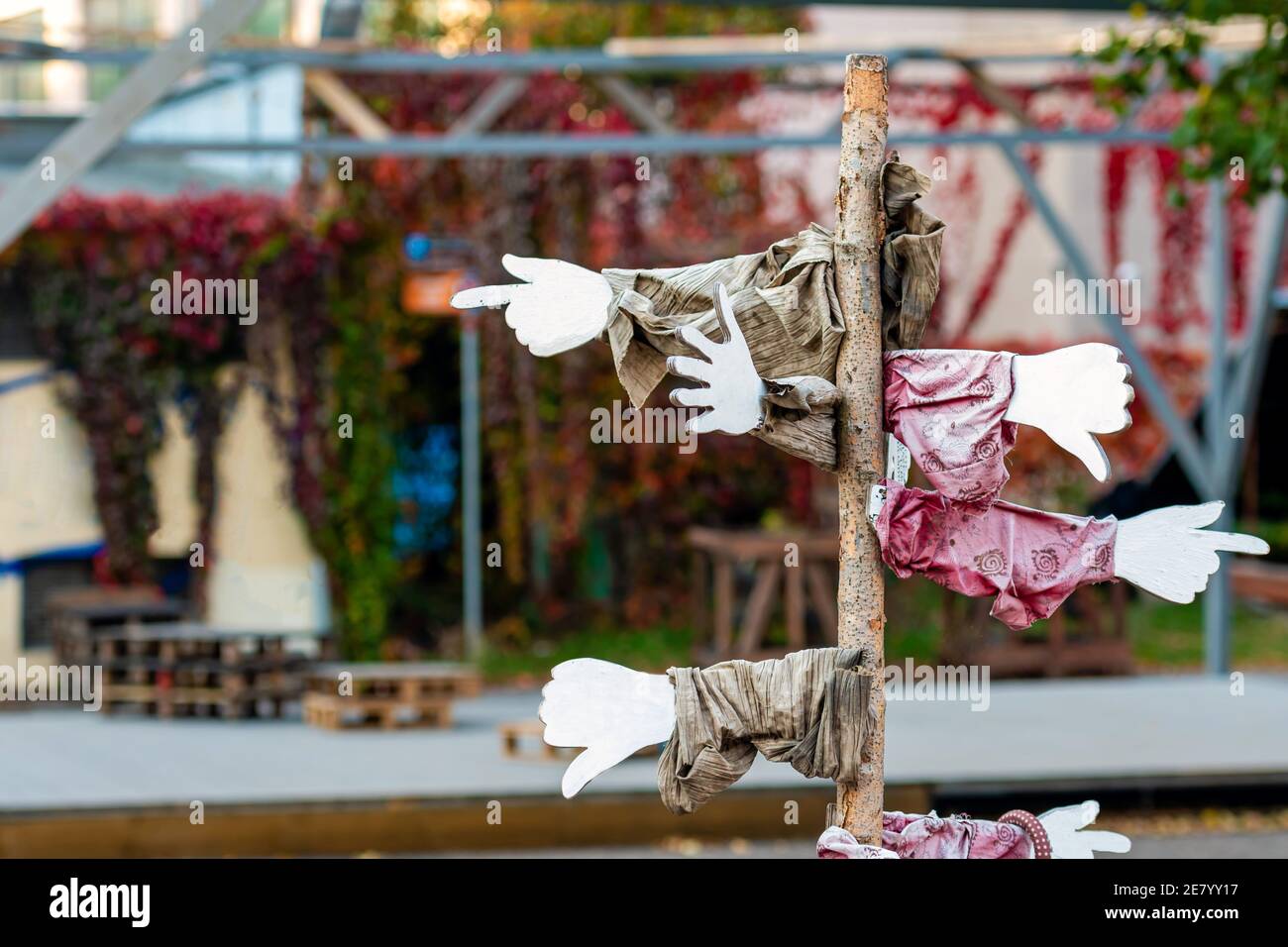 segni di puntatori in diverse direzioni contro una strada sfocata sckground Foto Stock