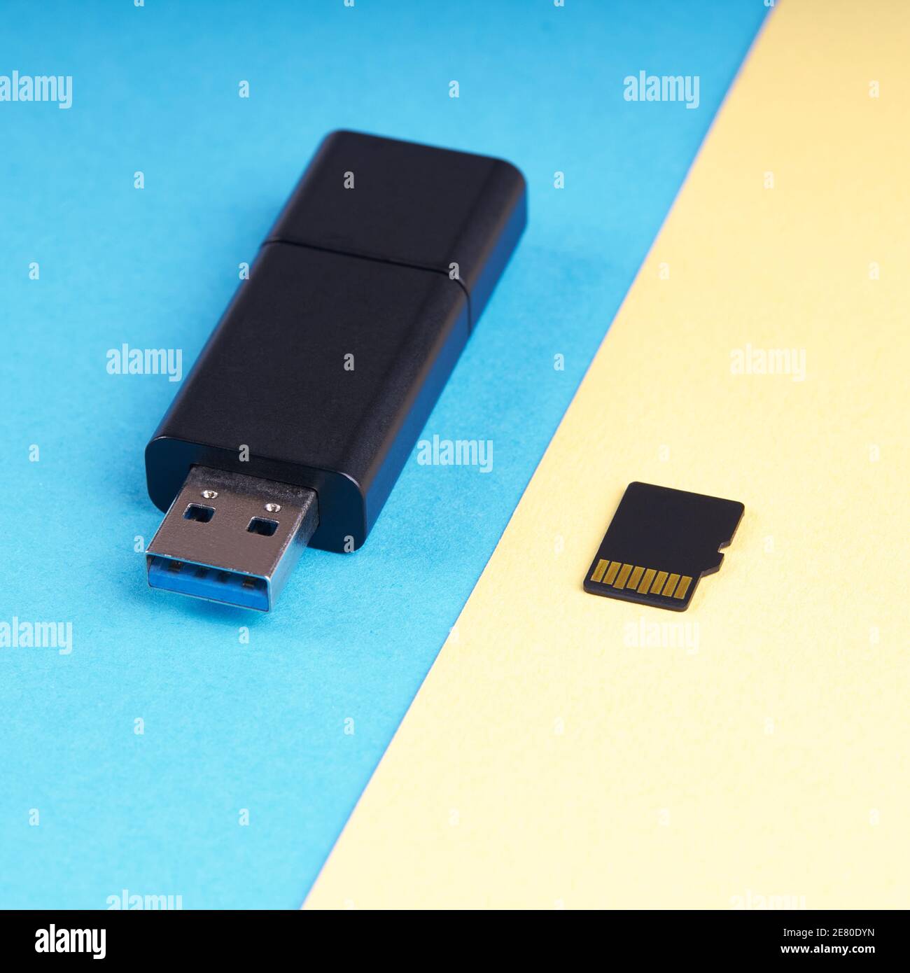 chiavetta usb e scheda di memoria micro sd su sfondo blu e giallo. diversi tipi di dispositivi di archiviazione portatili. concetto di archiviazione dei dati Foto Stock