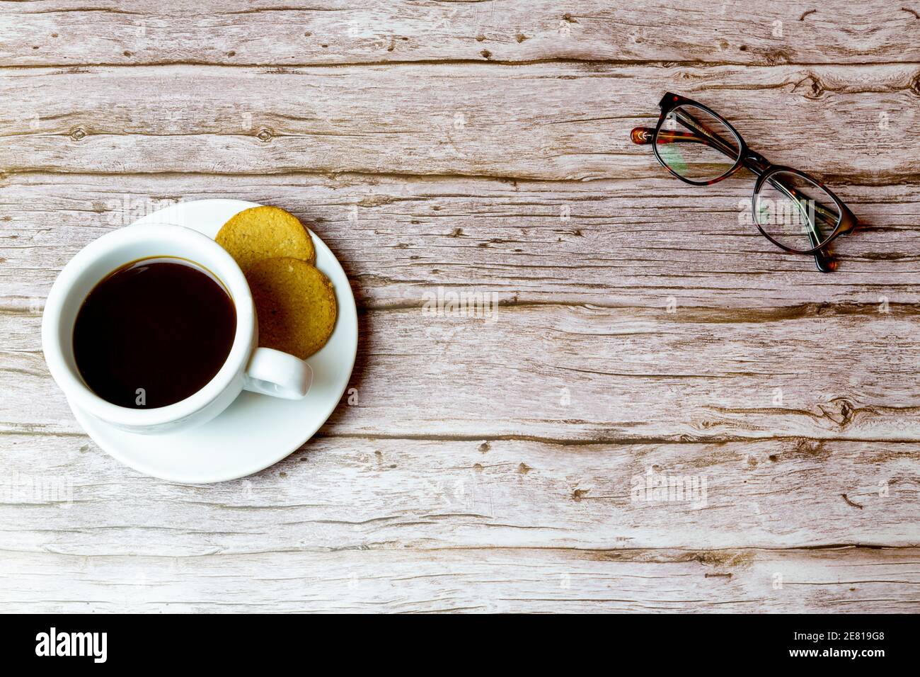 Un caffè e un paio di bicchieri posati su un tavola di legno ripresa dall'alto Foto Stock