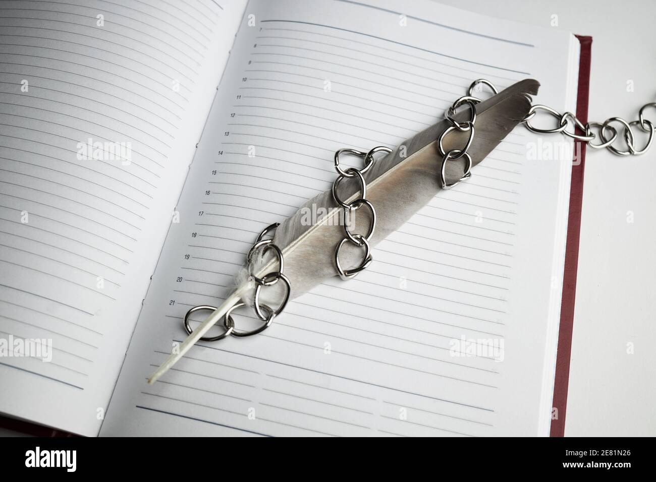 una penna con catena su blocco note vuoto. concetto di libertà di parola e giornalismo. spazio di copia. giornata mondiale della libertà di stampa Foto Stock