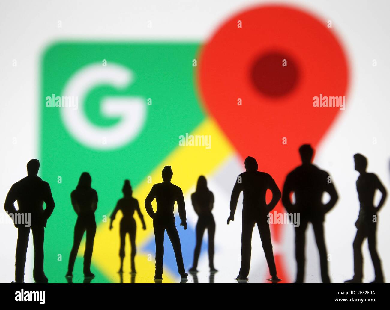 In questa illustrazione fotografica l'icona di Google Maps visualizzata davanti alle sagome delle persone. Foto Stock