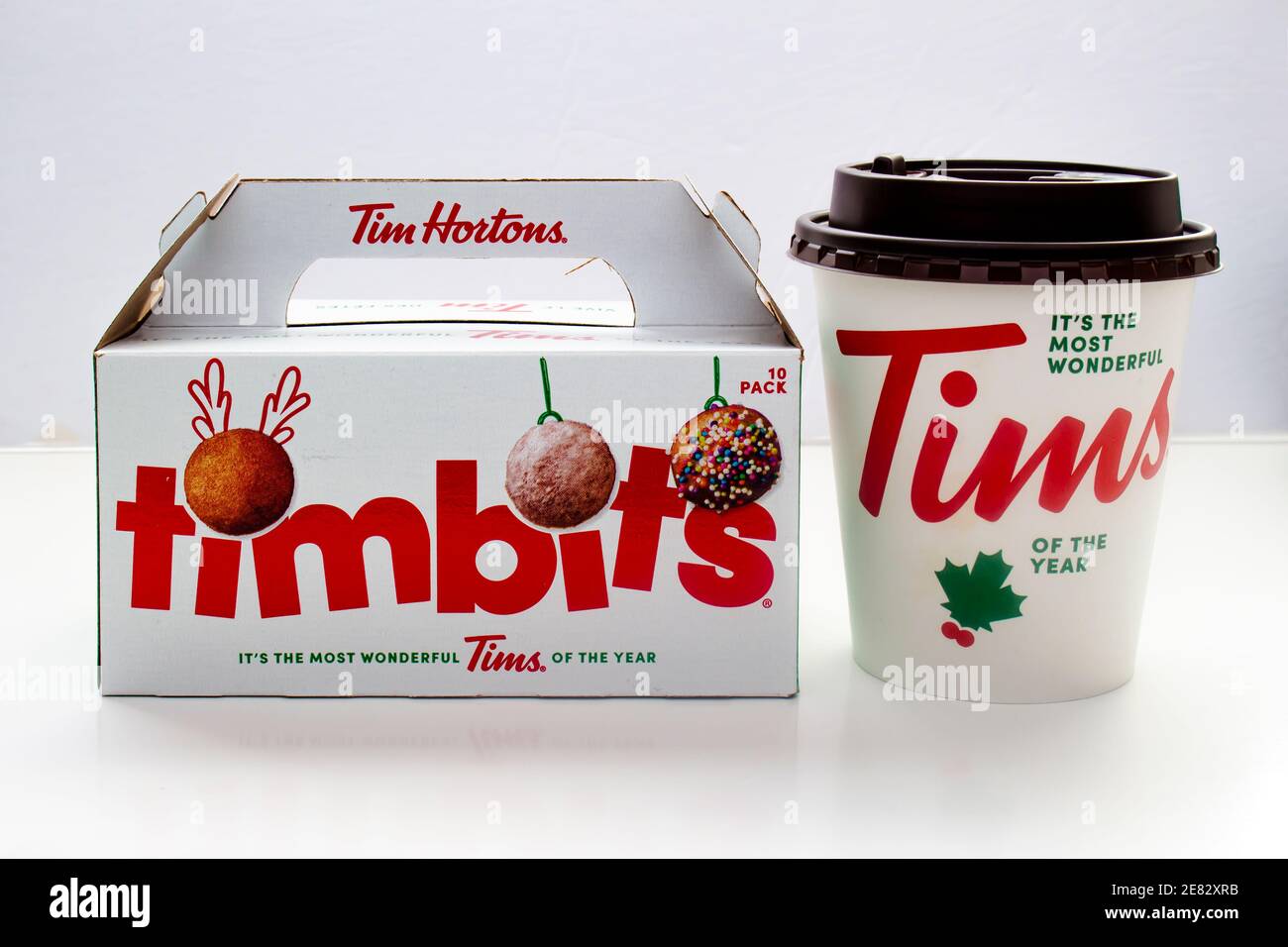 Calgary, Alberta. Canada. 29 gennaio 2021. Caffè di Natale Tim Hortons e scatola di Timbits su sfondo bianco Foto Stock