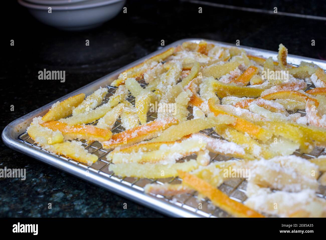 Bucce candite di arancia e limone riposante in una padella a. asciugare fino al completamento Foto Stock