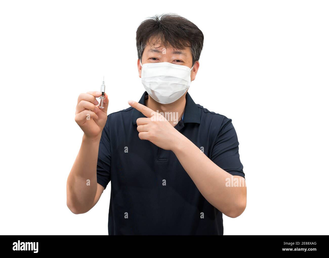 Un uomo asiatico di mezza età che indossa una maschera medica sta tenendo in mano una siringa di vaccino. Foto Stock