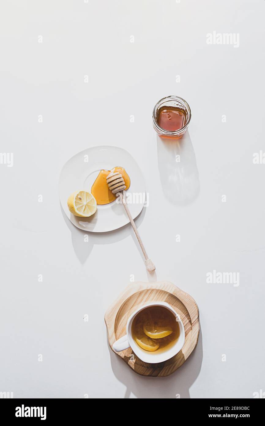 Tè alle erbe con miele e limone su sfondo chiaro, concetto di cibo sano. Minimalistica disposizione piatta con spazio per la copia. Foto Stock