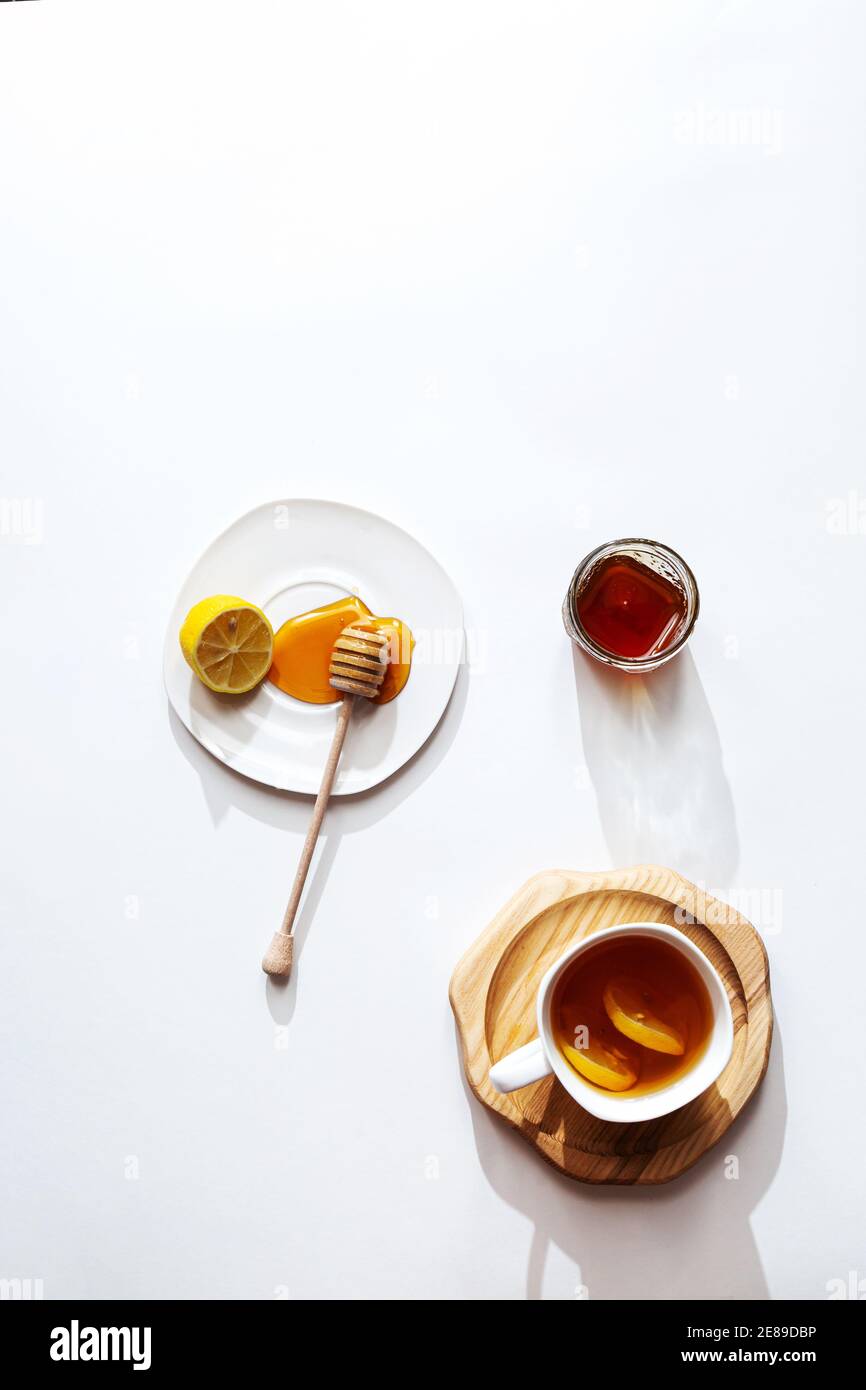 Tè alle erbe con miele e limone su sfondo chiaro, concetto di cibo sano. Minimalistica disposizione piatta con spazio per la copia. Foto Stock