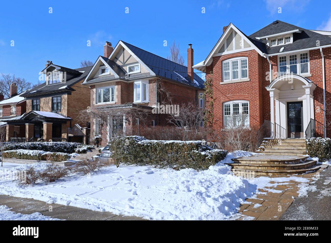 Via di case tradizionali di classe media singola famiglia su un giornata di sole in inverno Foto Stock