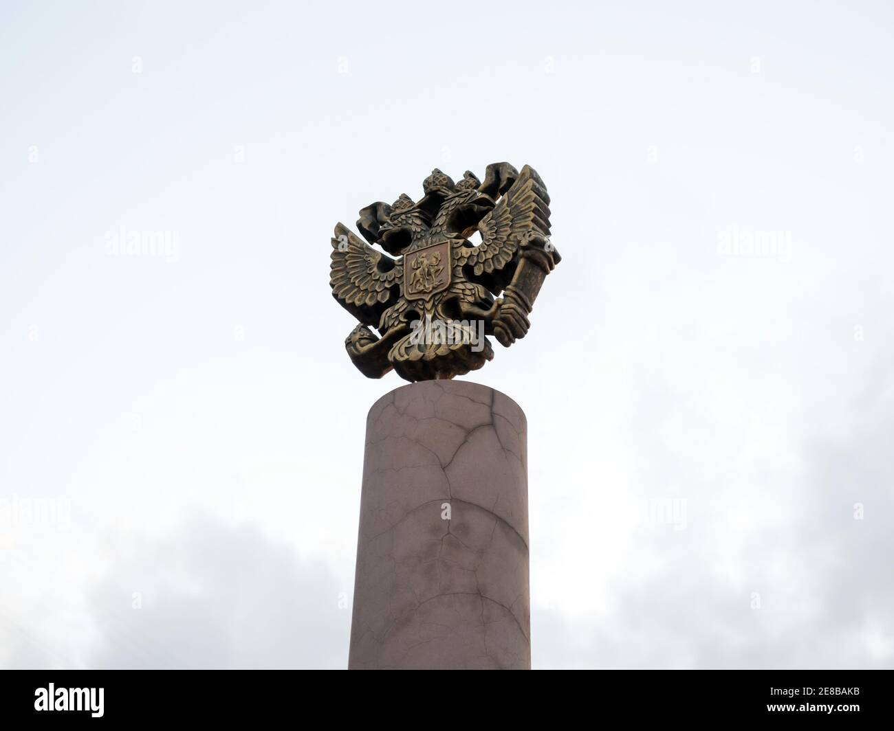 Lo stemma della Russia è il simbolo ufficiale della Federazione Russa (1993) gettata in bronzo sulla cima della colonna contro il cielo. Foto Stock