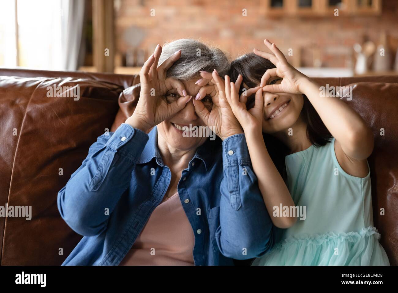 La testa ha girato il ritratto divertente della nonna matura sorridente e della nipote Foto Stock