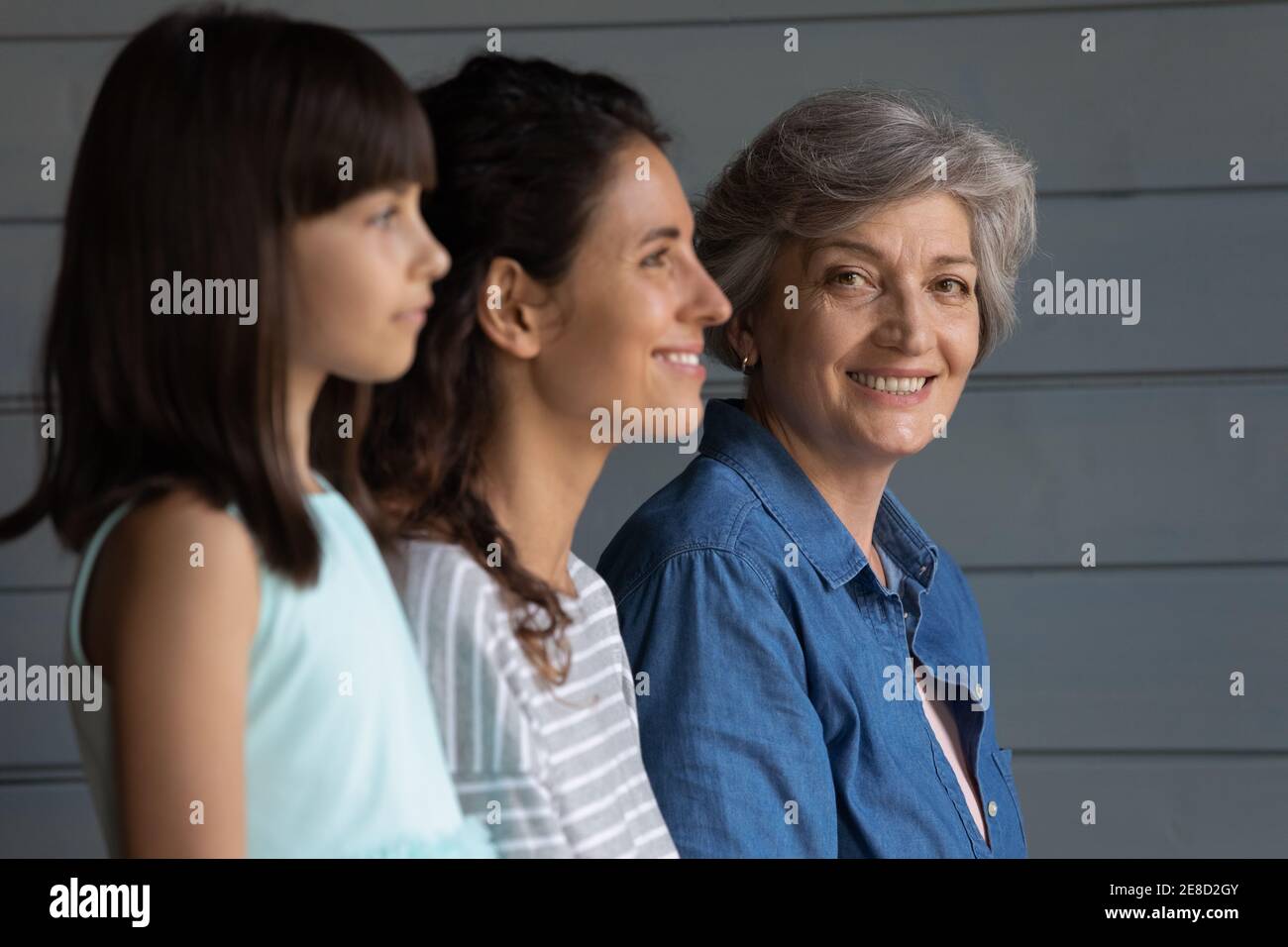 Testa ritratto girato sorridendo donna matura con figlia e nipote Foto Stock