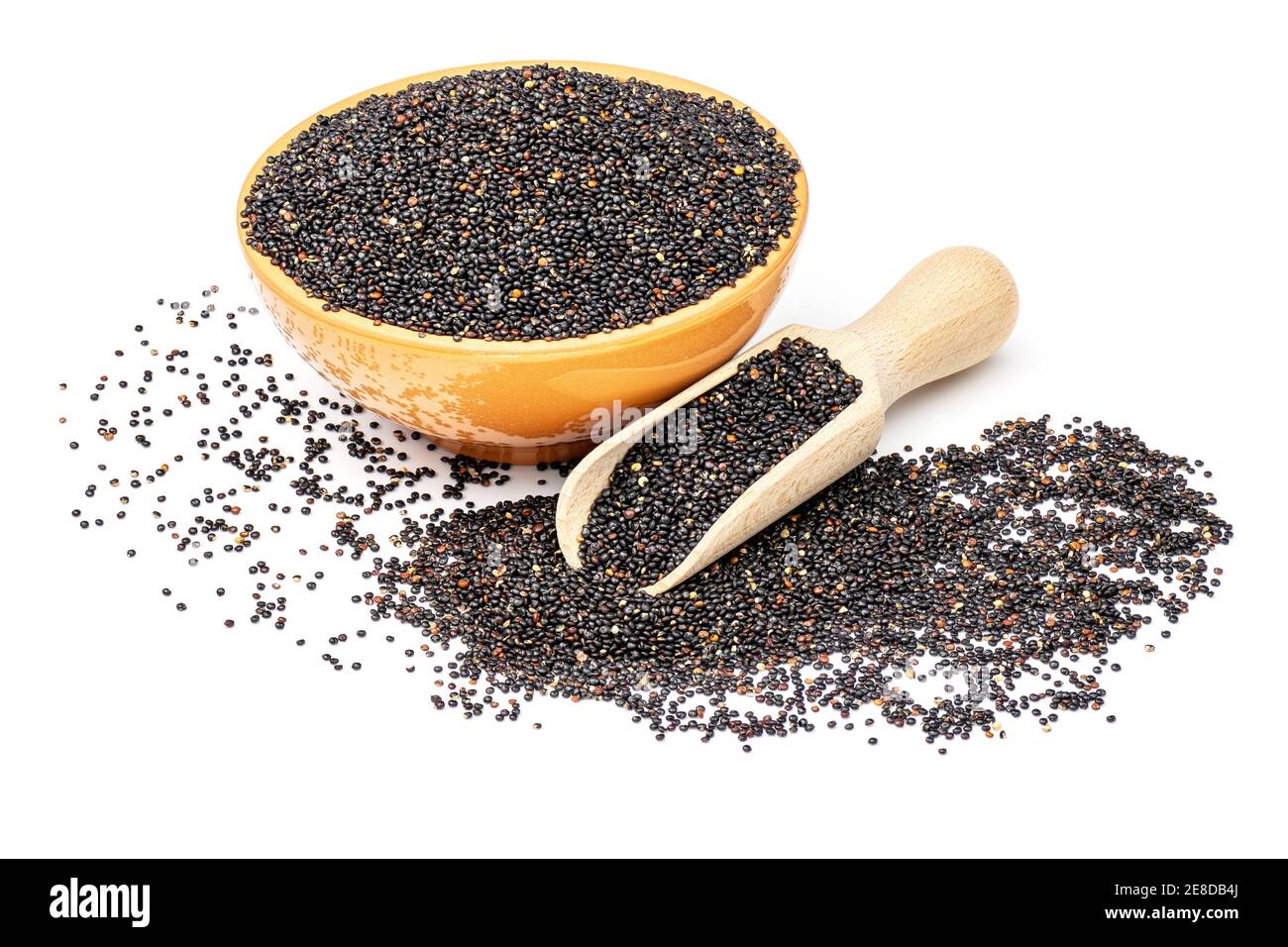 Quinoa cruda nera in ciotola arancione e paletta di legno isolata su fondo bianco. Foto Stock