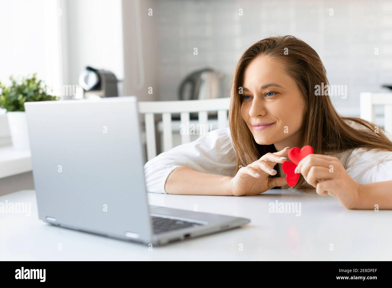 Giovane donna davanti allo schermo di un laptop durante una data online. Concetto di San Valentino. Foto Stock