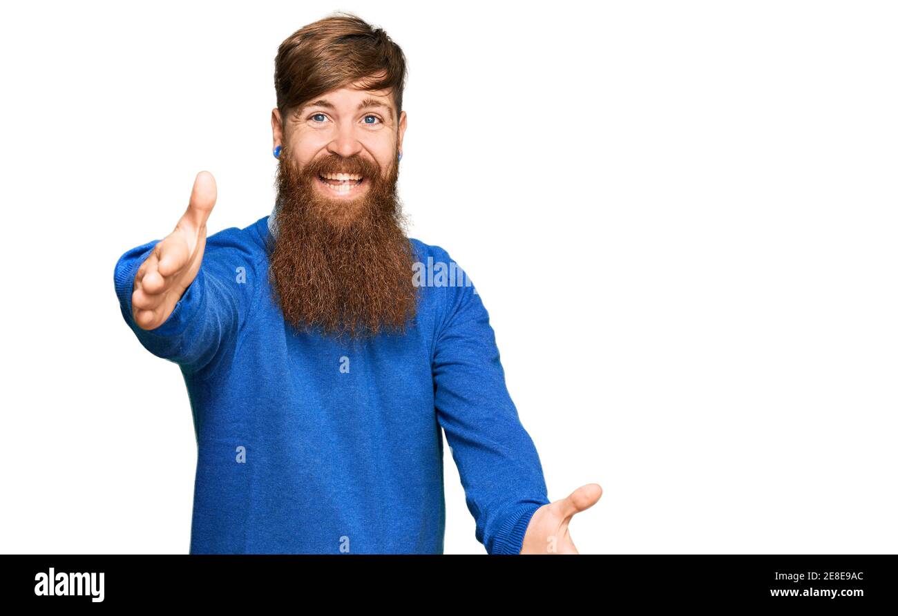 Giovane irlandese rosso uomo che indossa abiti casual guardando la macchina fotografica sorridente a braccia aperte per abbraccio. Espressione allegra abbracciando la felicità. Foto Stock