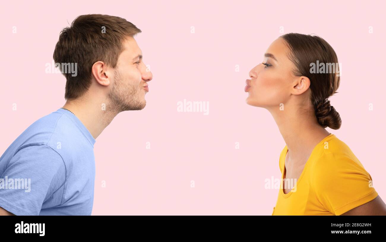 L'uomo e la donna si raggiungono a vicenda cercando di baciare Foto Stock