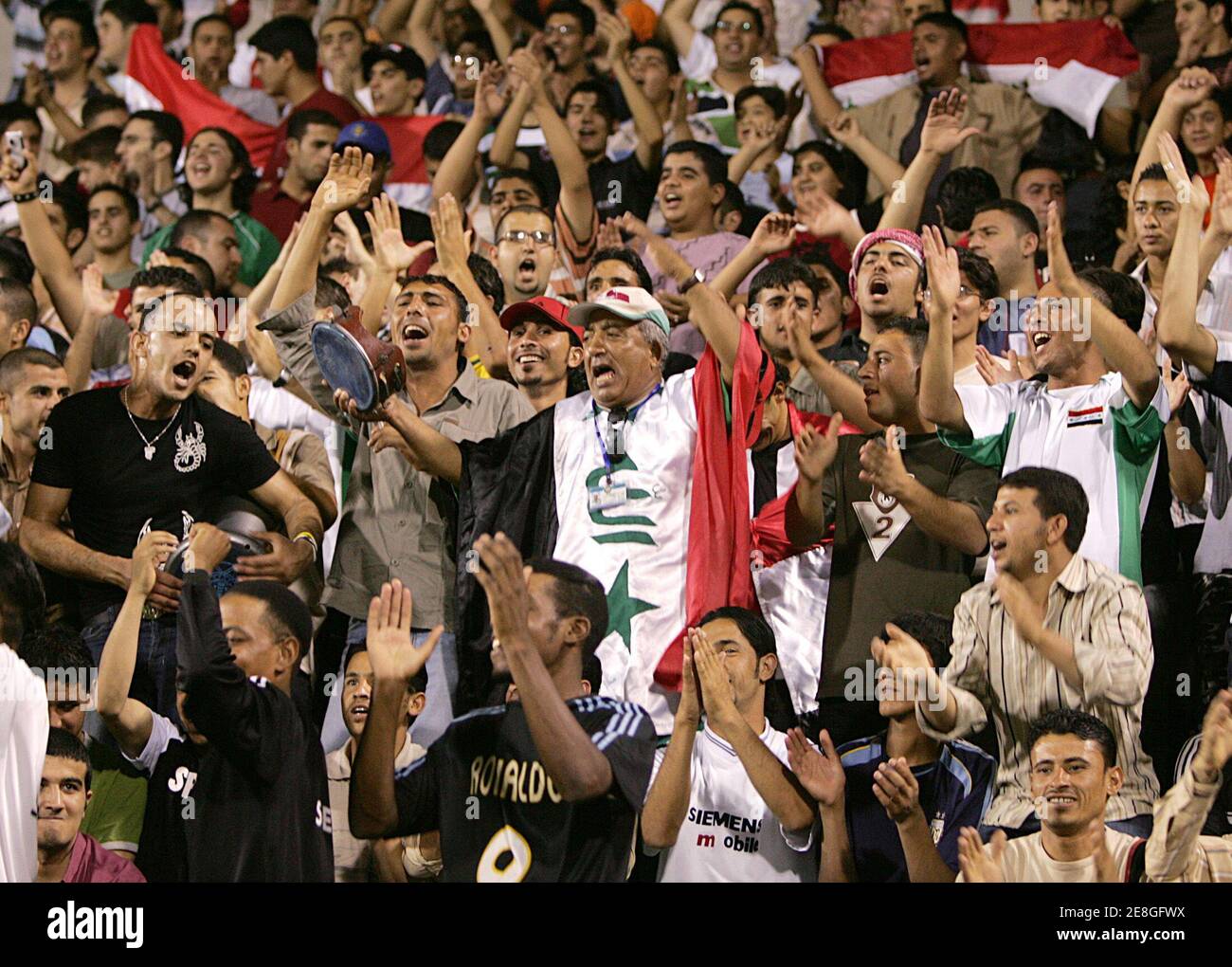 I tifosi iracheni incoraggiano la loro squadra nazionale di calcio durante la loro partita di calcio di qualificazione Asian Cup contro la Palestina ad Amman il 17 agosto 2006. REUTERS/Ali Jarekji (GIORDANIA) Foto Stock