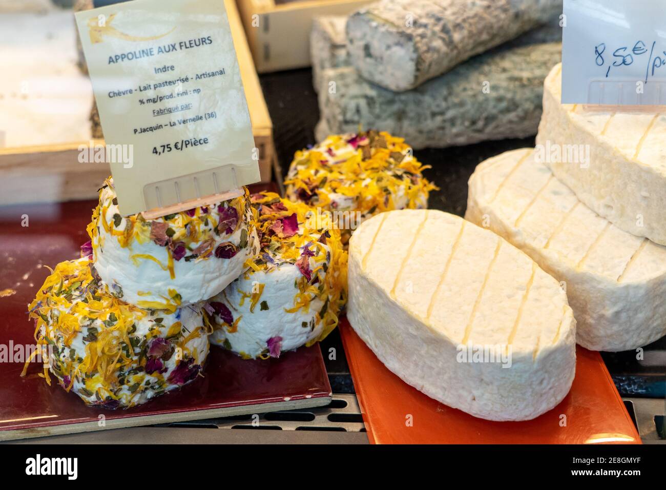Mercato Domenica a Bordeaux. Una varietà di formaggio di capra. Pecora di capra decorata con petali di fiori secchi. Foto Stock