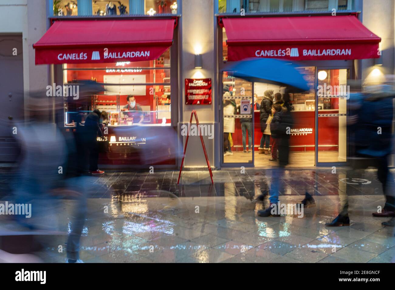 Bordeaux, Francia. Pasticceria Canelé. Giorno piovoso e persone che camminano lungo Rue Sainte Catherine. Foto Stock