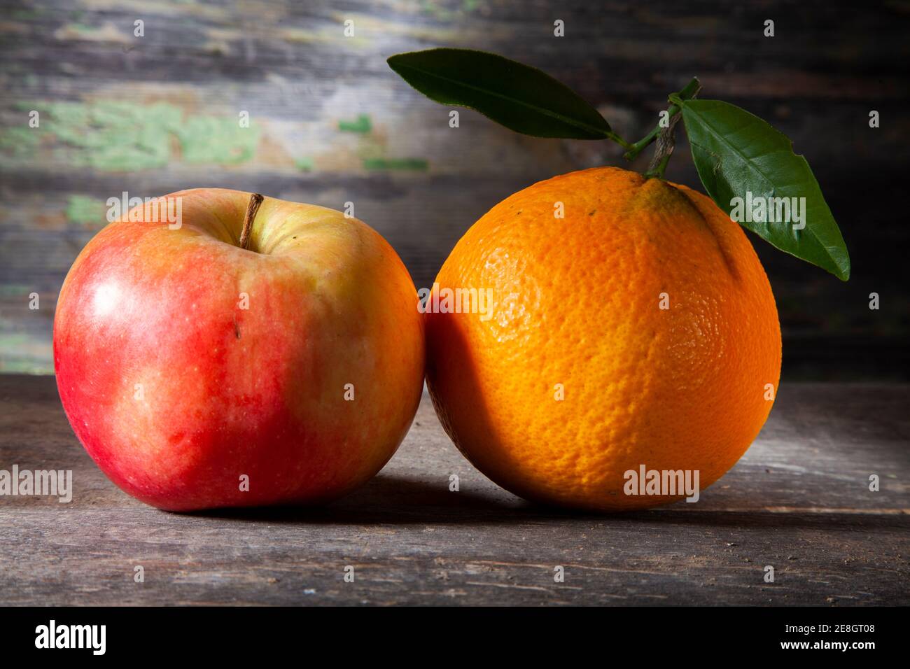 Autunno Still Life of Orange e Apple. Macro Foto di su tavola di legno con sfondo decaduto. Presa con Spotlight in Studio Foto Stock