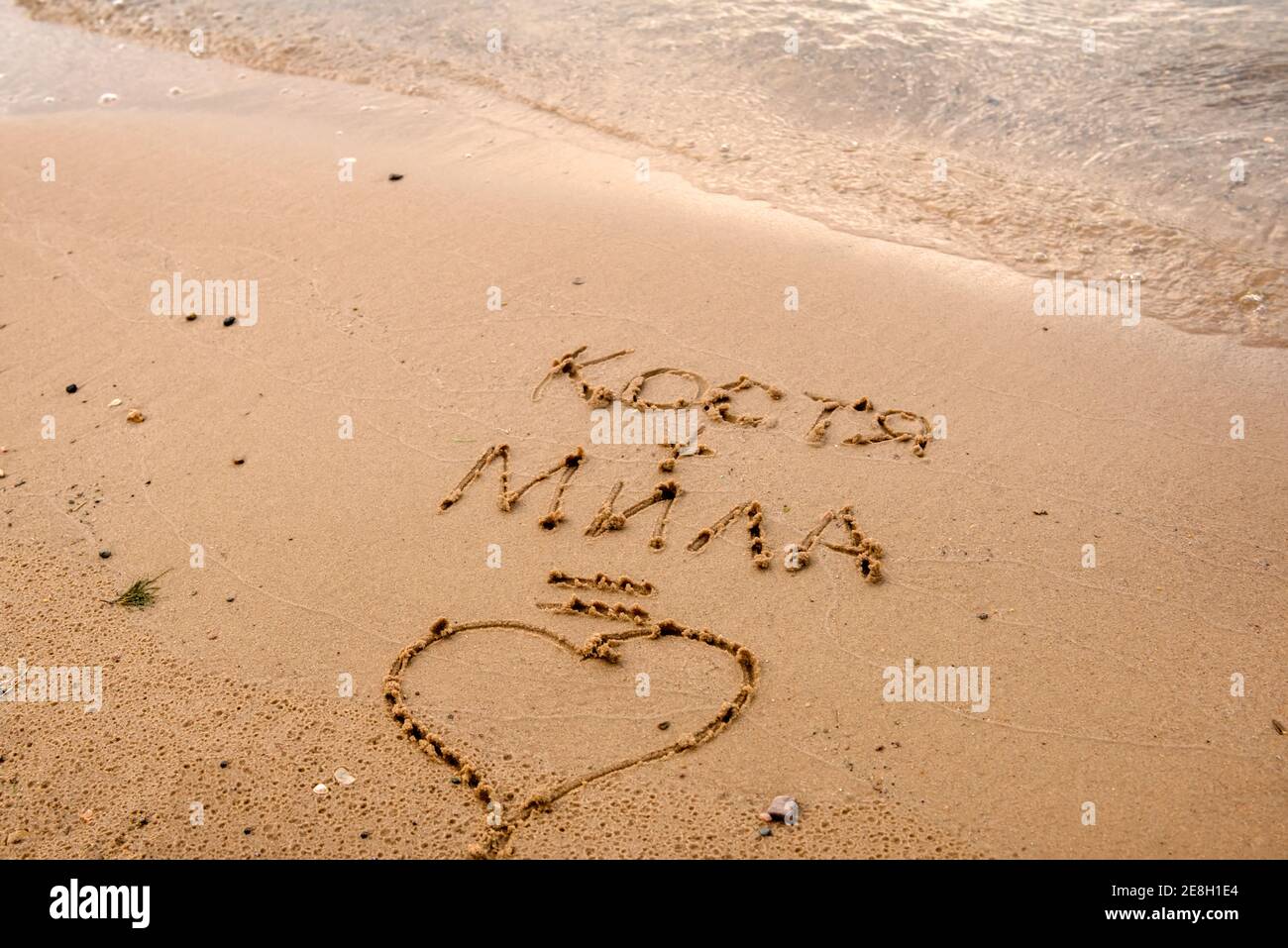Dichiarazione d'amore sulla sabbia della spiaggia. I nomi delle lettere equivalgono all'amore Foto Stock