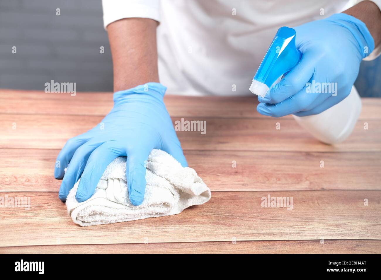 per pulire il tavolo, utilizzare guanti monouso con spray disinfettante  superficie Foto stock - Alamy