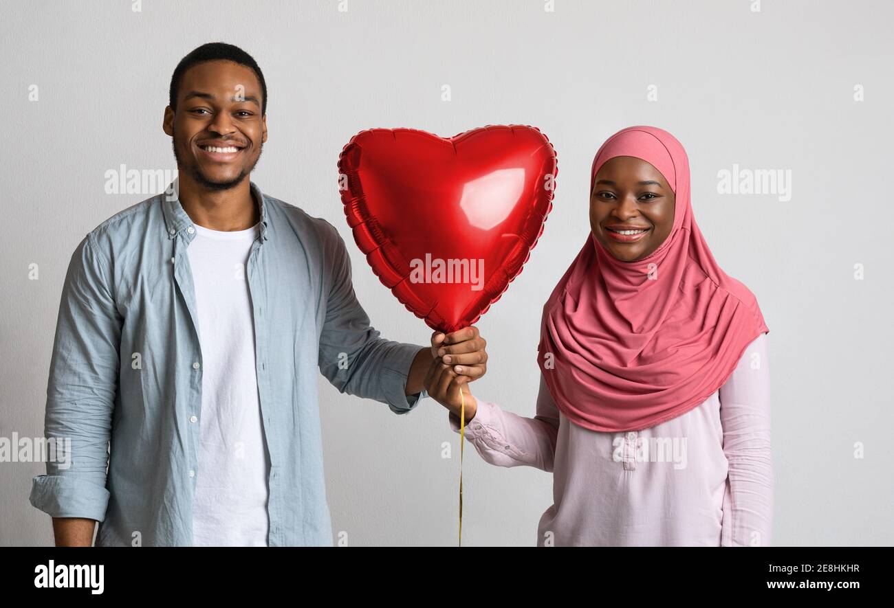 Felice coppia nera che tiene il pallone d'amore insieme Foto Stock