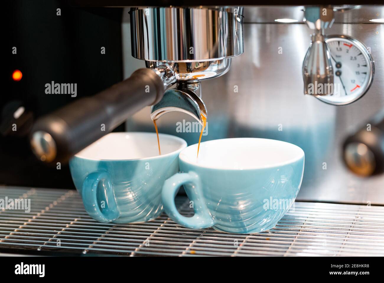 Macchina da caffè professionale per versare il caffè in piccole tazze in ceramica caffetteria con attrezzature moderne Foto Stock