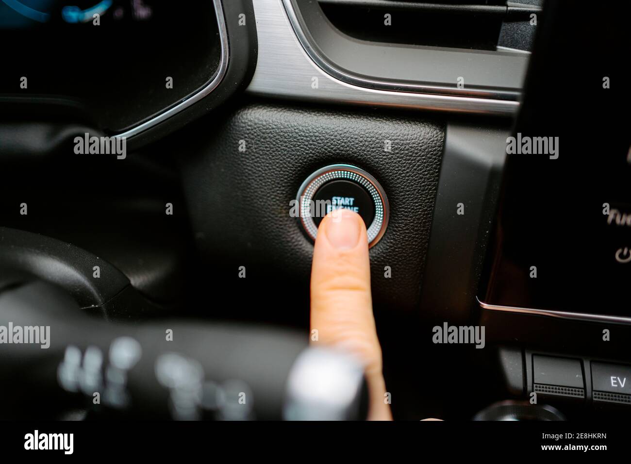 Primo piano del prodotto anonimo maschio premendo il pulsante Start Engine Stop (Avvia arresto motore) mentre si è seduti in un'auto moderna prima di guidare Foto Stock
