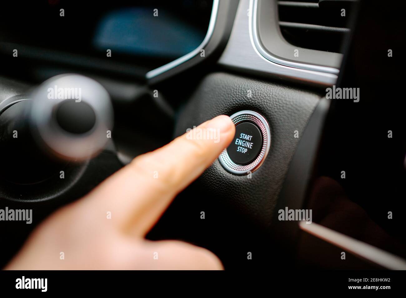 Primo piano del prodotto anonimo maschio premendo il pulsante Start Engine Stop (Avvia arresto motore) mentre si è seduti in un'auto moderna prima di guidare Foto Stock