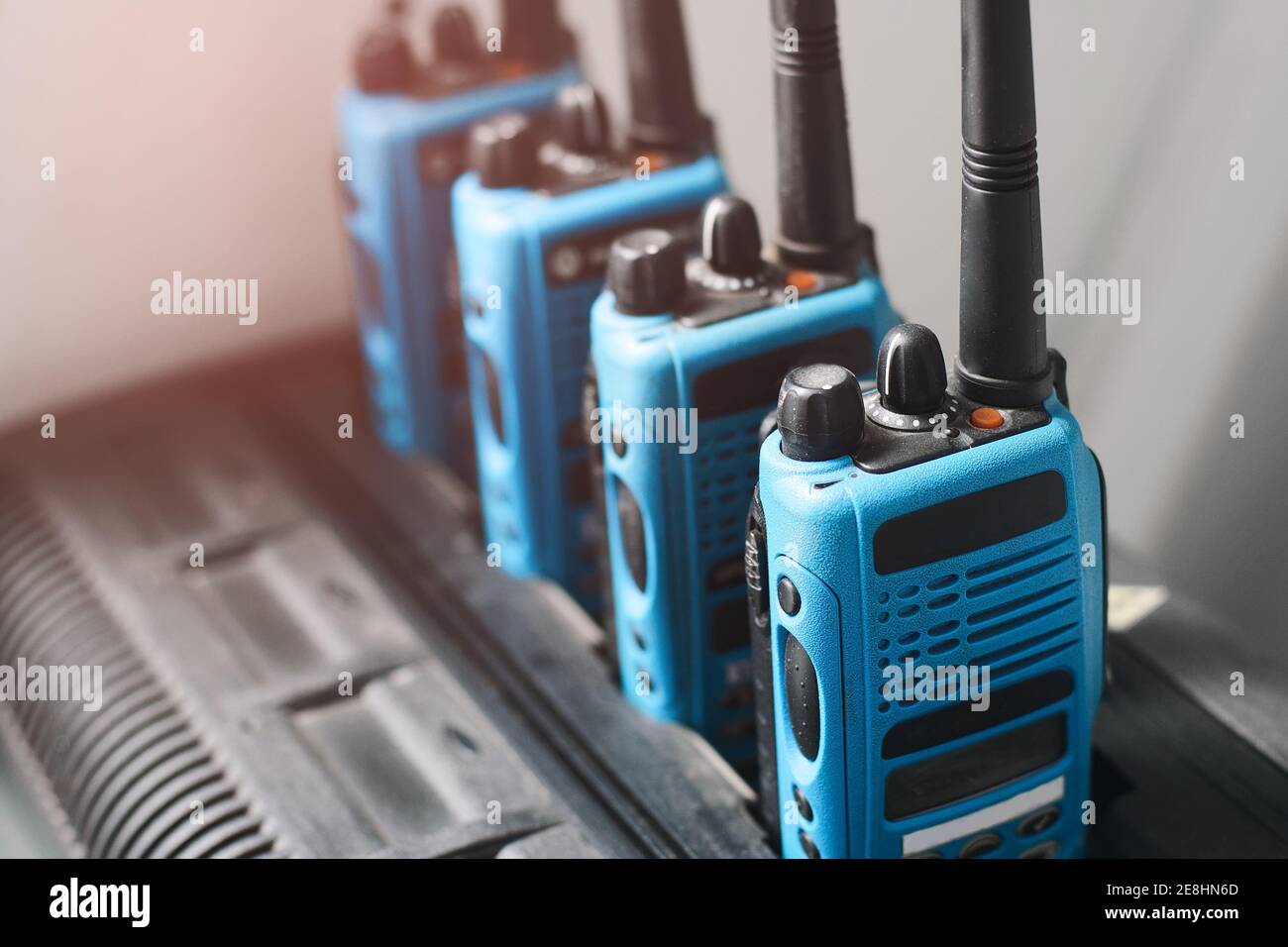 Un set di walkie-talkie blu si trova in una fila. Dispositivo per la trasmissione di comunicazioni radio stabili a distanza. Foto Stock