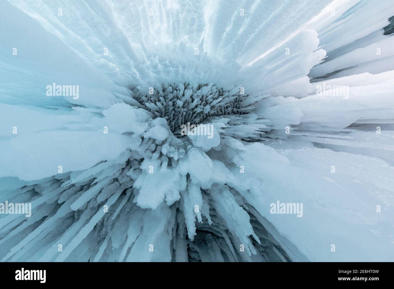 Da sotto di enormi icicles appesi alla grotta rocciosa vicino Lago Baikal in inverno come sfondo astratto Foto Stock
