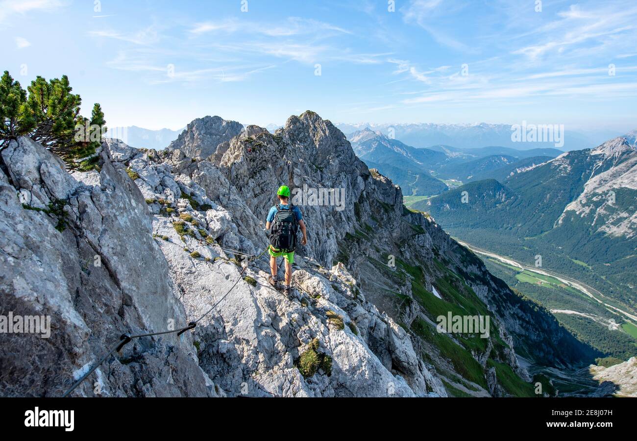 L'alpinista si arrampica su un percorso di corda fisso, Mittenwalder Hoehenweg, vista sulla valle dell'Isar vicino a Mittenwald, Karwendel Mountains, Mittenwald Foto Stock