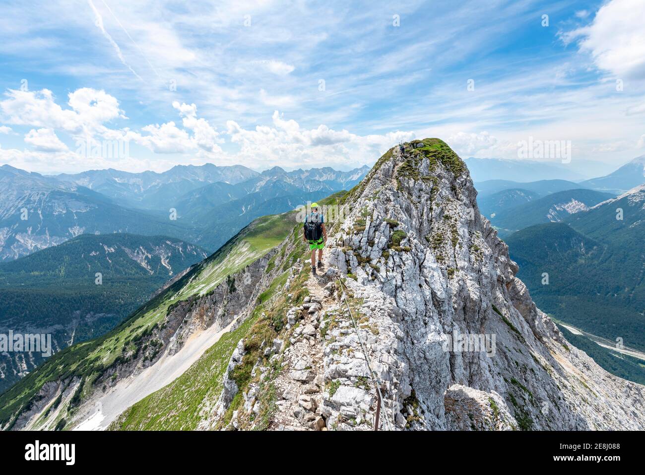 Alpinista su un crinale su una ferrata sicura, Mittenwalder Hoehenweg, vista sulla valle dell'Isar vicino a Mittenwald, Karwendel Mountains, Mittenwald Foto Stock