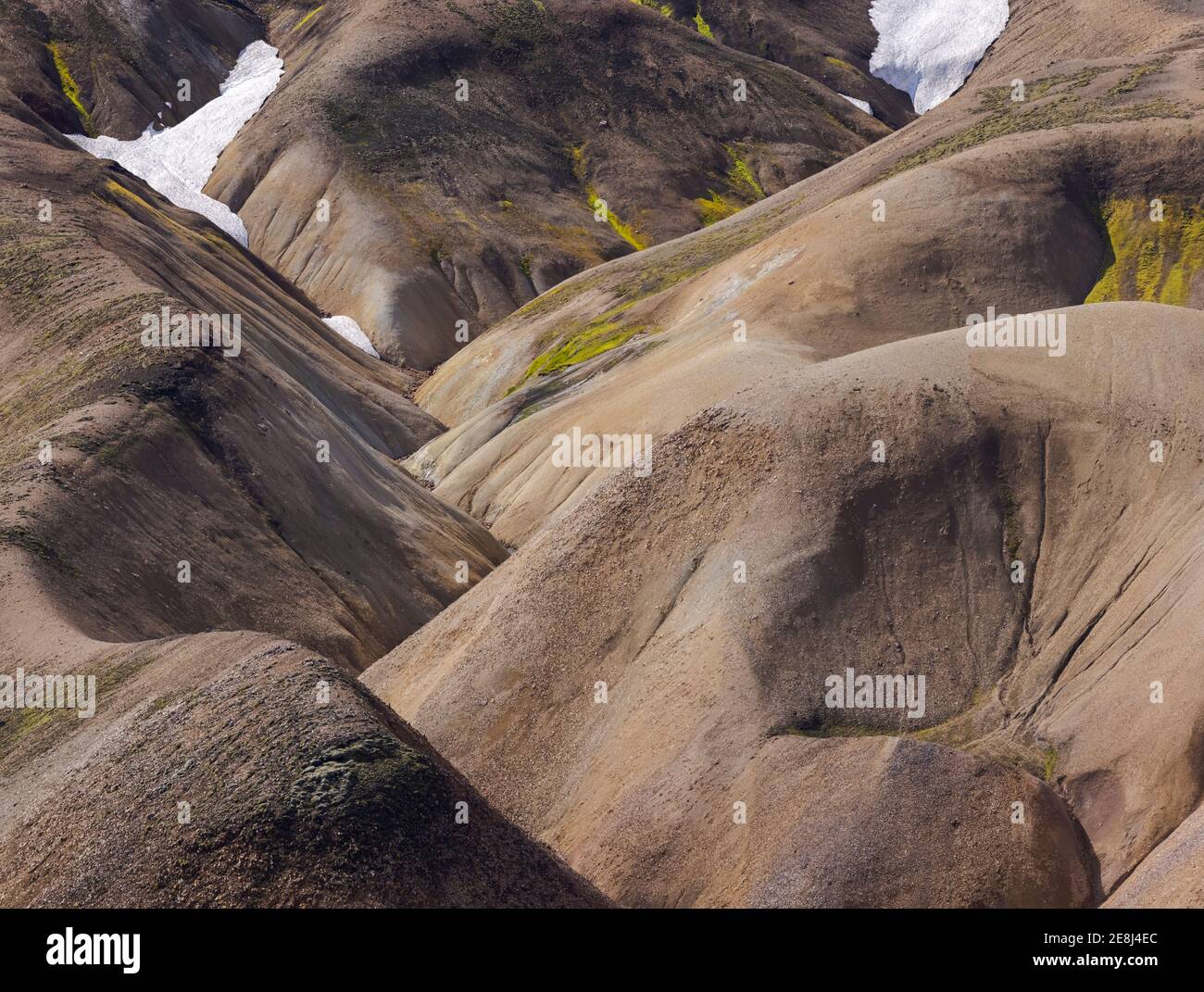 Vista pittoresca su un vasto terreno collinare coperto di erba secca e la neve in natura tranquilla nella luce del giorno Foto Stock