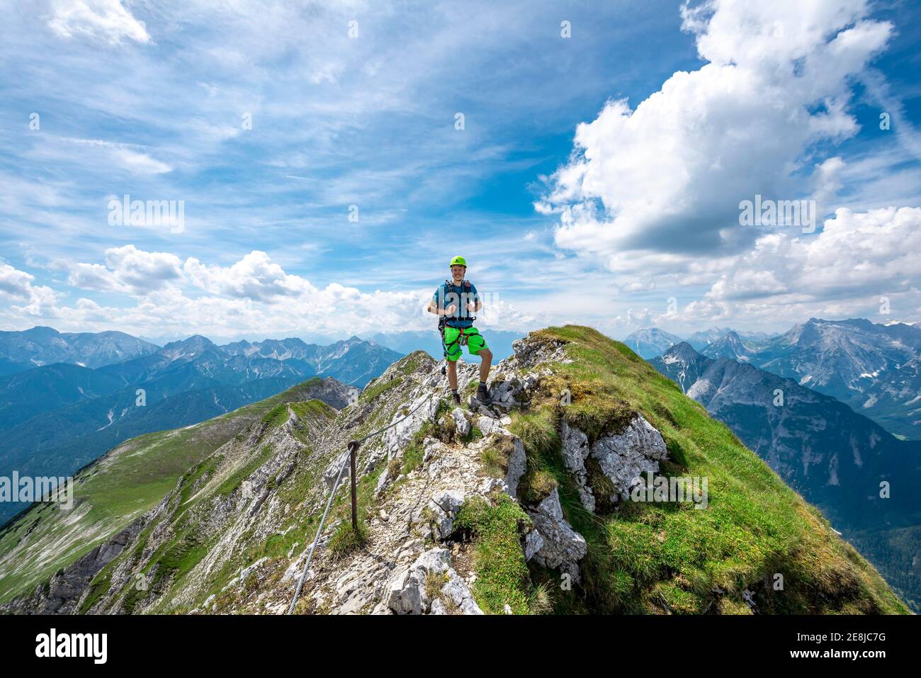 Alpinista su una cresta su un percorso fisso di corda, Mittenwalder Hoehenweg, vista del panorama montano, Karwendel Montagne, Mittenwald, Baviera Foto Stock