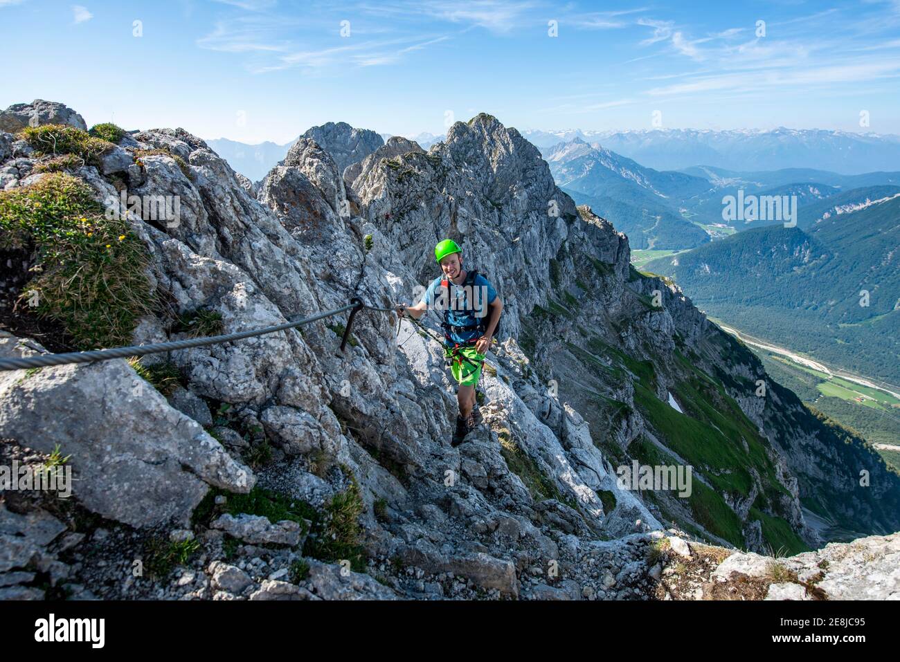 L'alpinista si arrampica su un percorso di corda fisso, Mittenwalder Hoehenweg, vista sulla valle dell'Isar vicino a Mittenwald, Karwendel Mountains, Mittenwald Foto Stock