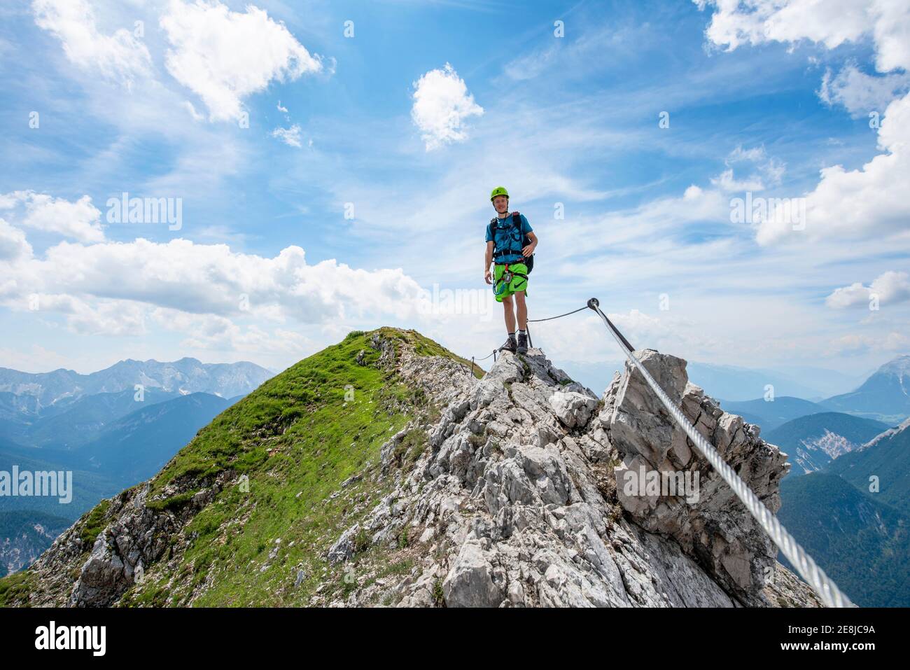 Alpinista su una cresta su un percorso fisso di corda, Mittenwalder Hoehenweg, vista del panorama montano, Karwendel Montagne, Mittenwald, Baviera Foto Stock