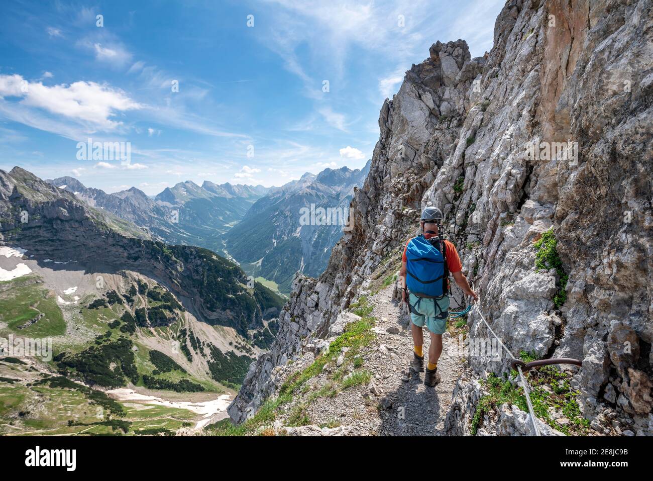 Alpinista su una ferrata protetta, Mittenwalder Hoehenweg, vista sulla valle del Karwendel, Karwendel montagne, Mittenwald, Baviera, Germania Foto Stock