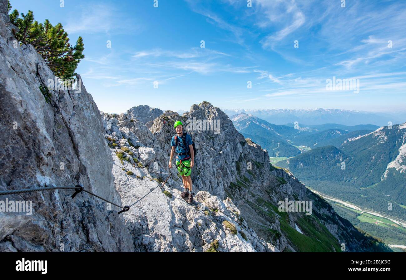 L'alpinista si arrampica su un percorso di corda fisso, Mittenwalder Hoehenweg, vista sulla valle dell'Isar vicino a Mittenwald, Karwendel Mountains, Mittenwald Foto Stock