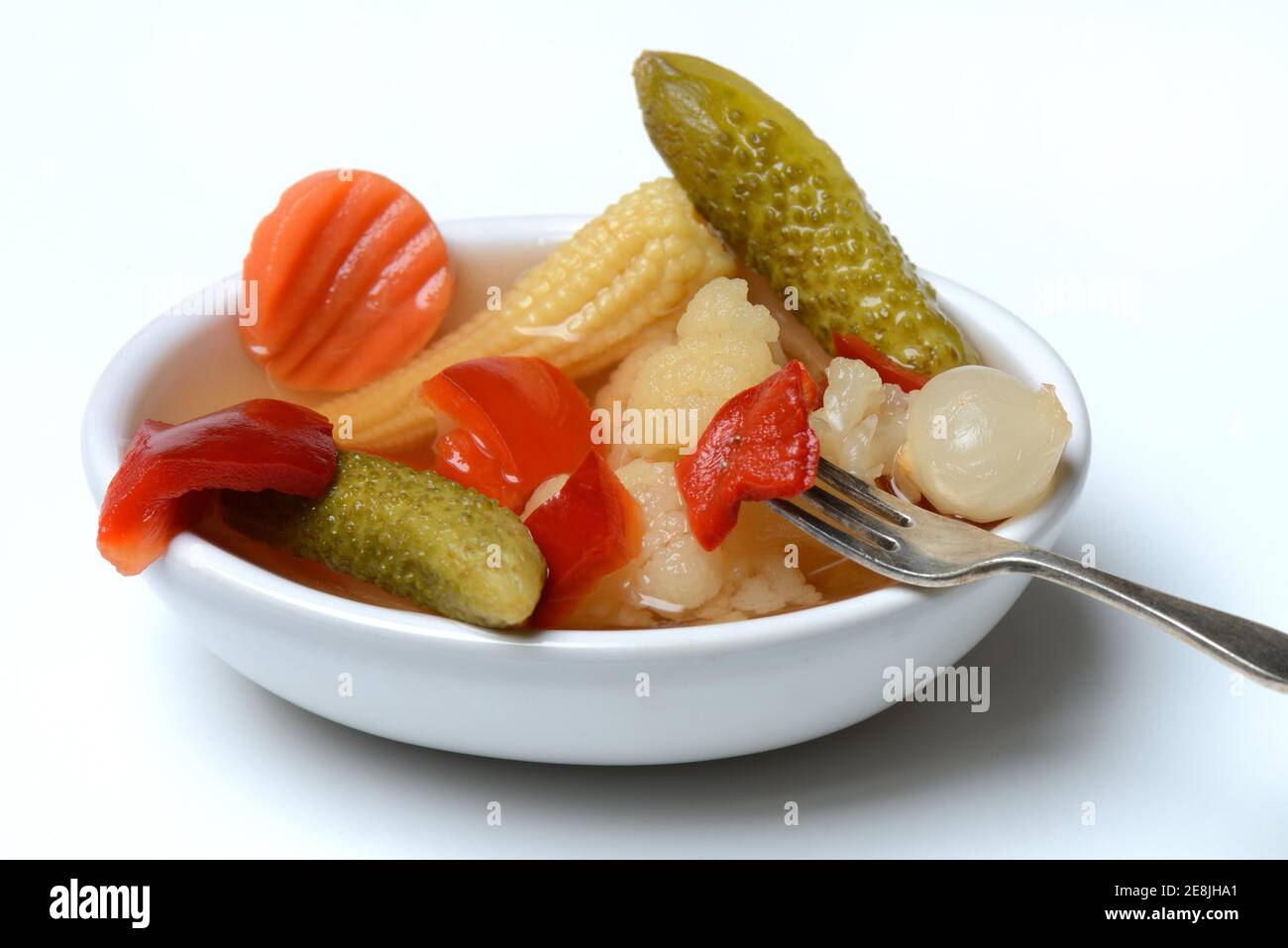 Impastare sottaceti con carote, cavolfiori, cetrioli, cipolle e mais sulla pannocchia in un recipiente con forchetta, sottaceto, sottaceto Foto Stock