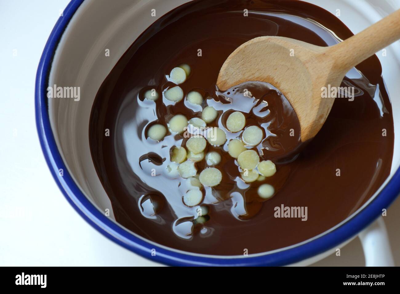 Rivestimento liquido di cioccolato e burro di cacao fuso con cucchiaio (Theobroma cacao), oleum cacao Foto Stock