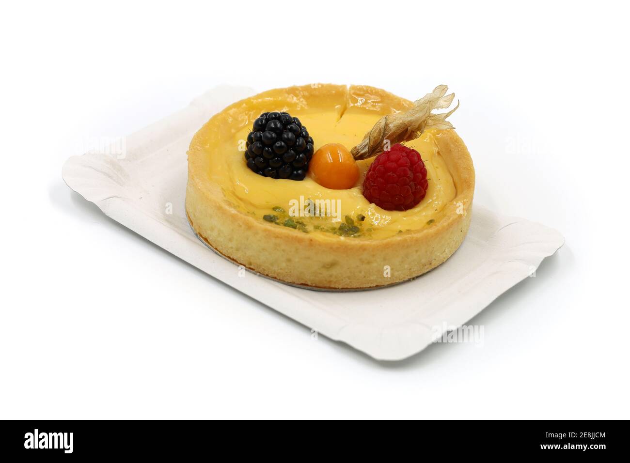 deliziosa torta piccola con frutta fresca di fisalis, mora e lampone su un piatto di carta isolato su bianco Foto Stock