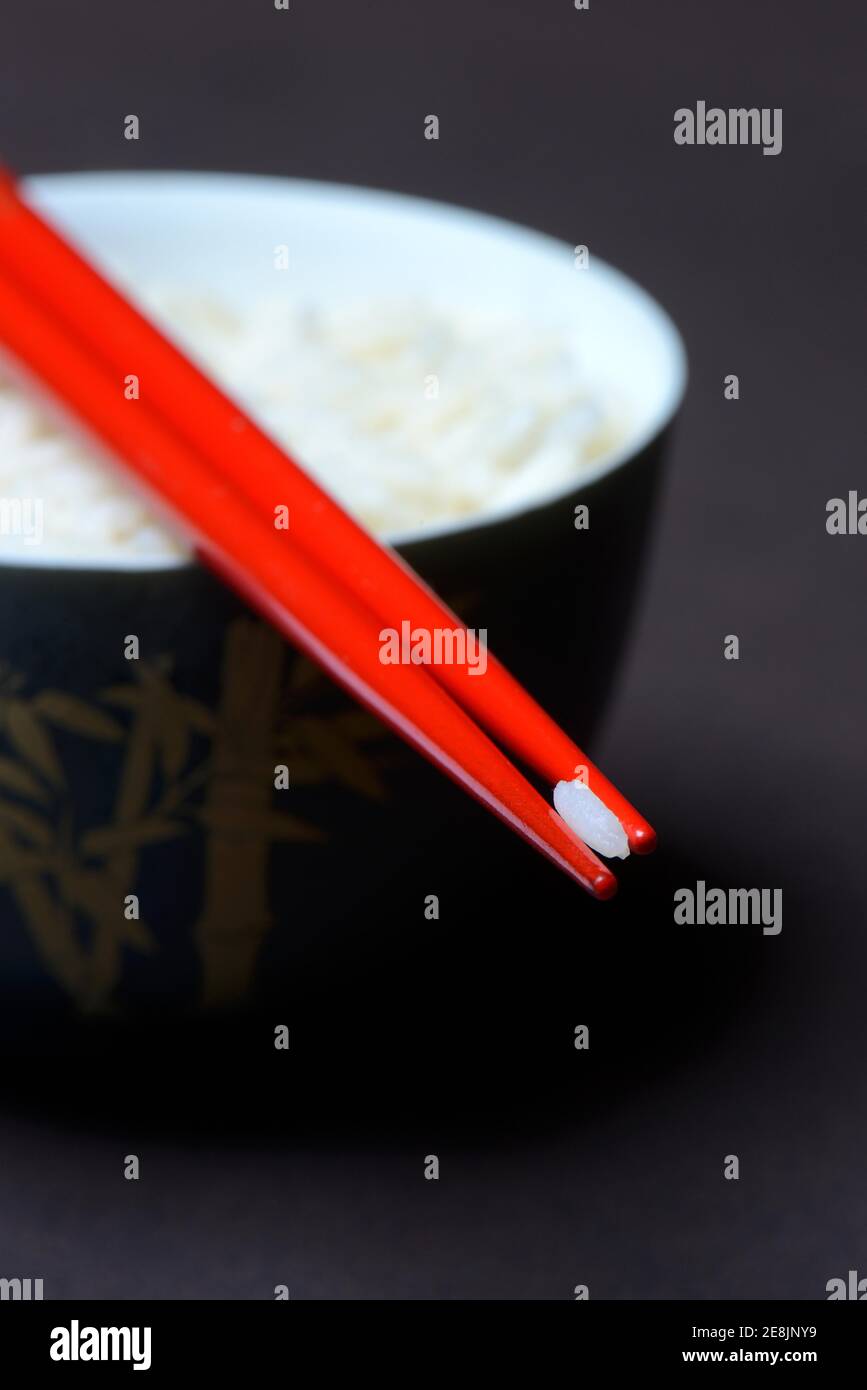 Grano di riso su chopsticks, riso basmati, Oryza sativa, cotto Foto Stock