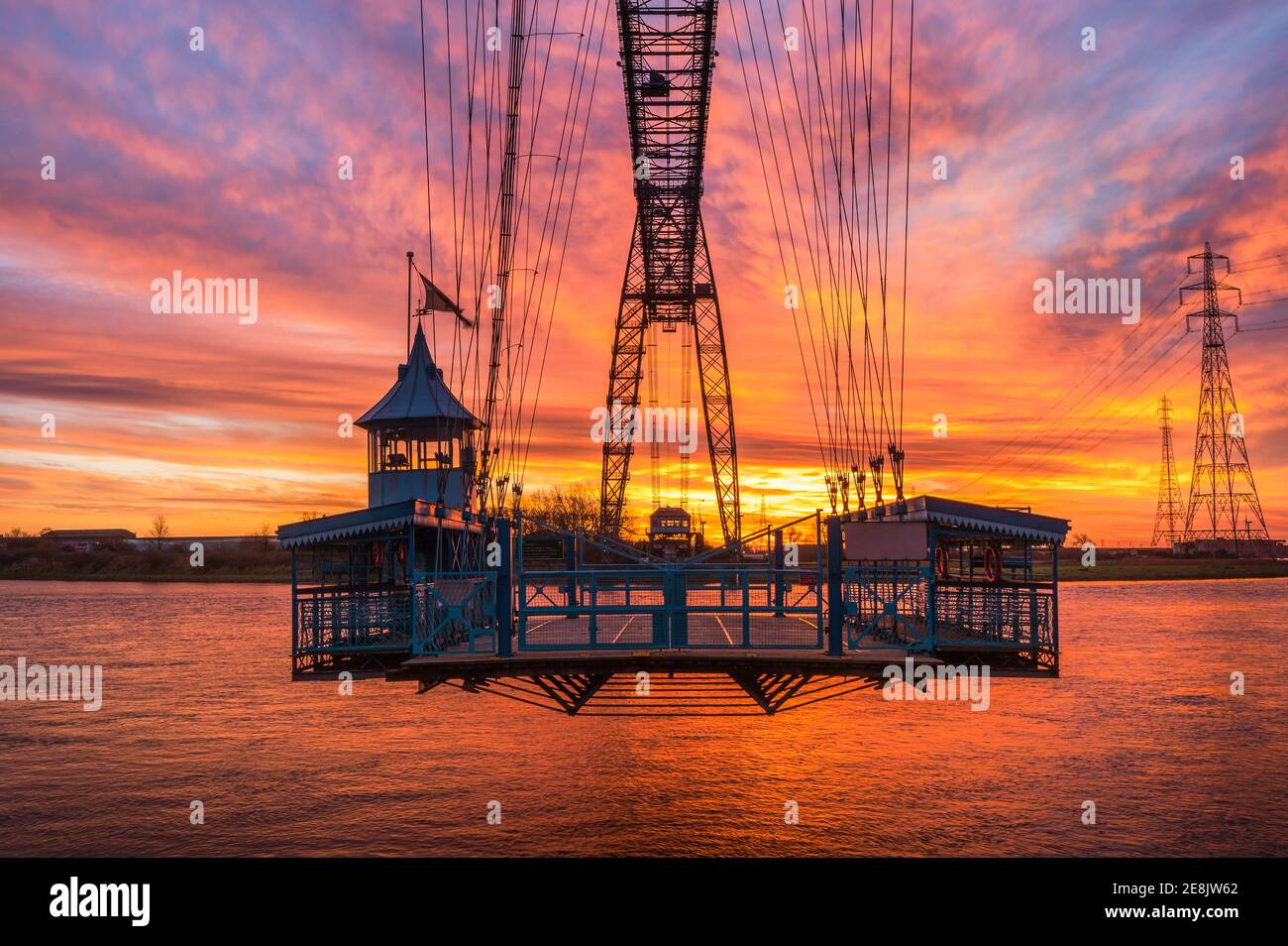 Il sole sorge dietro la funivia del Newport Transporter Bridge Foto Stock