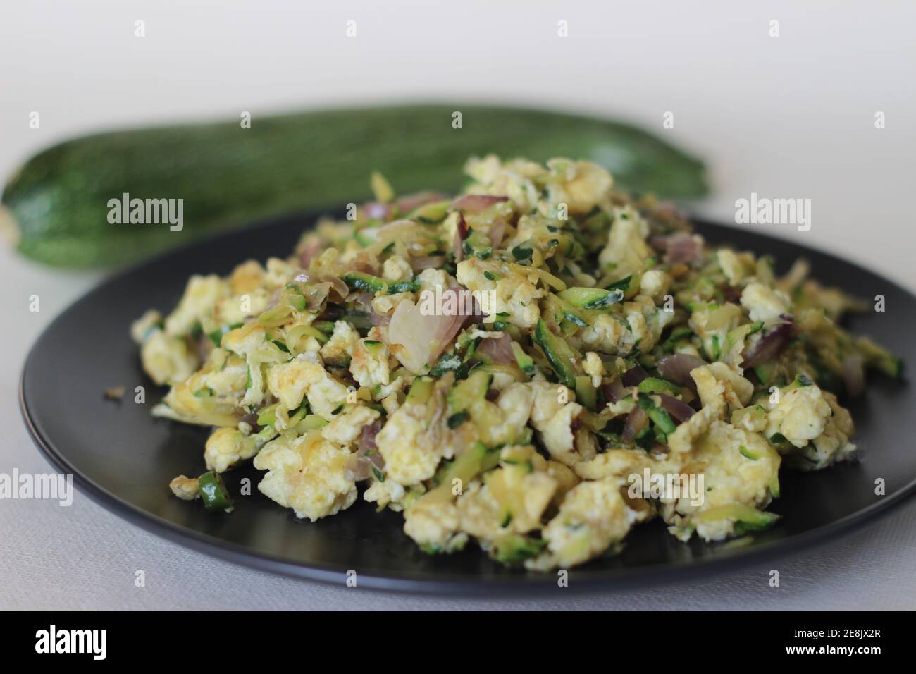 Uova strapazzate con zucchine verdi grattugiate per una sana colazione Foto Stock