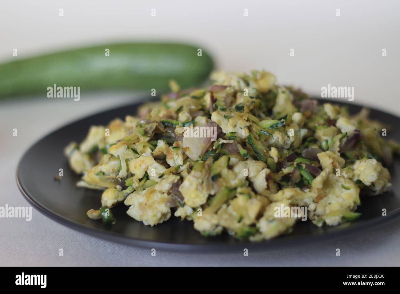 Uova strapazzate con zucchine verdi grattugiate per una sana colazione Foto Stock