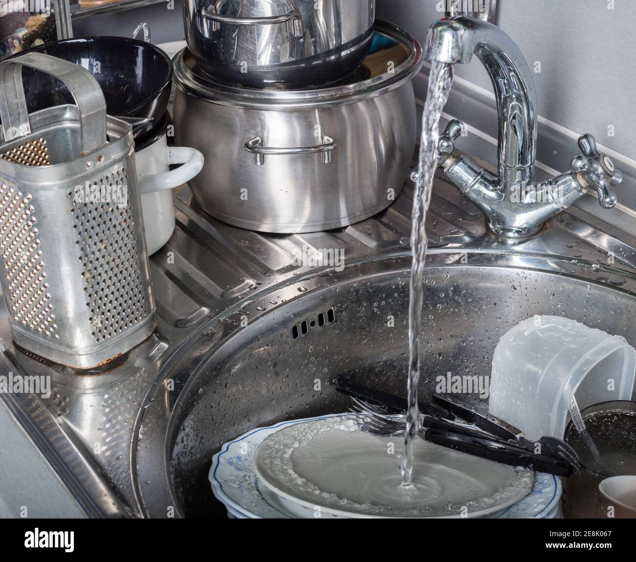 Pila di piatti sporchi nel lavello da cucina Foto Stock